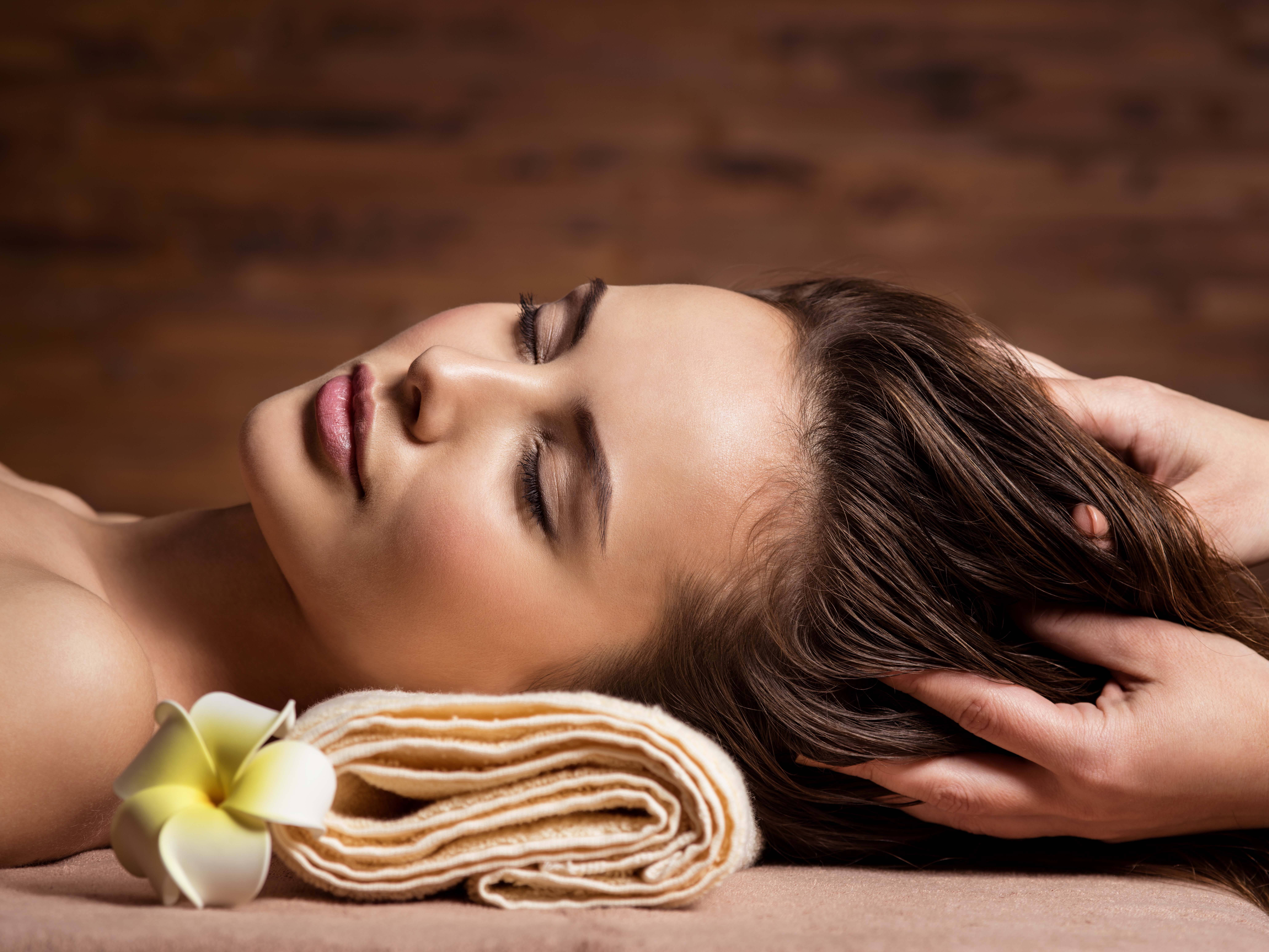 Masseur doing massage the head and hair for an woman in spa salon
